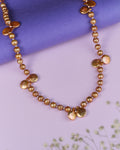 The Umpteen Blossom Pearl Necklace by Chandrani Pearls exudes refined elegance with its irregularly shaped gold accents set against a purple background.