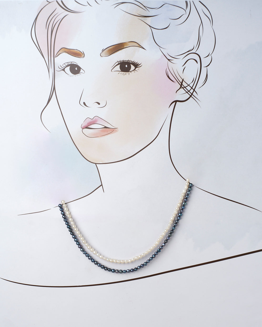 Two elegant Careen Axis Pearl Necklaces, one white and one black from Chandrani Pearls, rest on a purple and pink surface decorated with small white flowers. Perfect for elevating your wedding style.