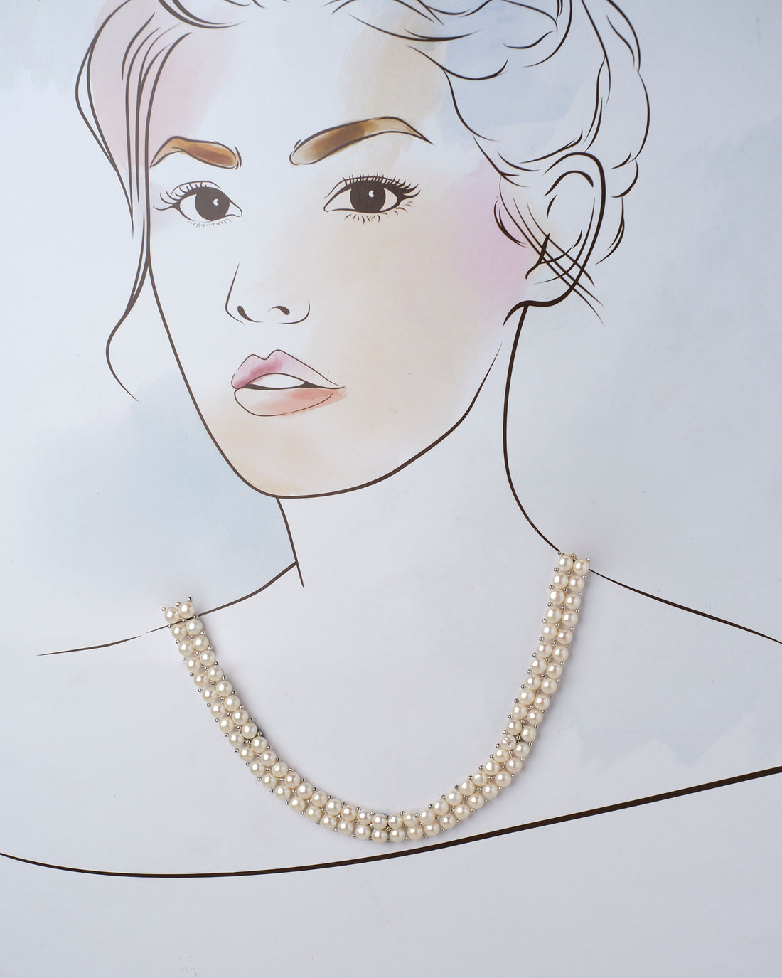 The Wit White Pearl Necklace by Chandrani Pearls elegantly shines against a purple and pink backdrop, accented by small decorative plants.