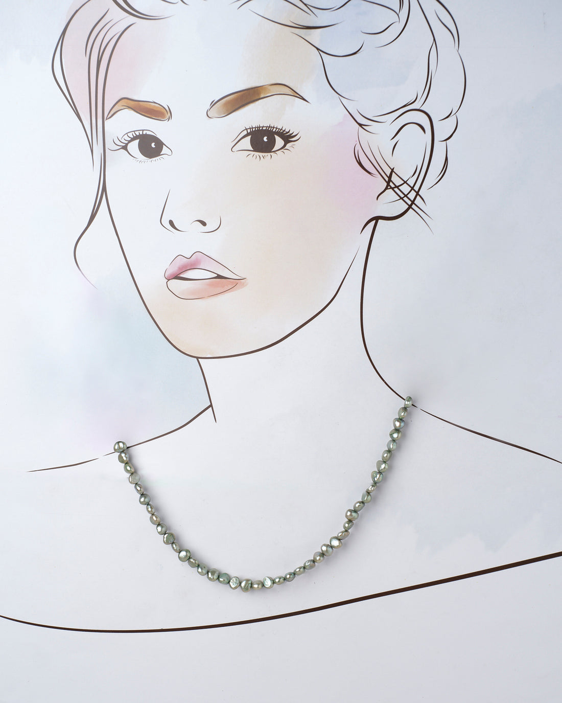 The Rangavati-Full of Colours Pearl Necklace by Chandrani Pearls, featuring stylish irregular gray pearls, is showcased on a purple surface with dried flowers in the foreground.