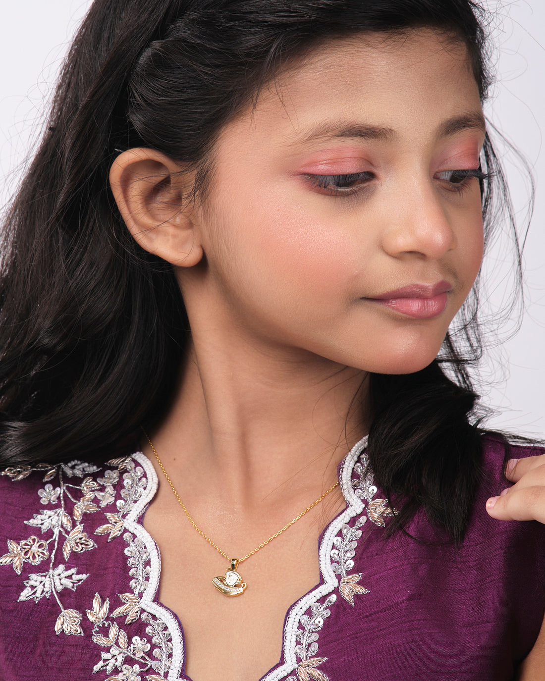 The Kiddie Pretty Pendant by Chandrani Pearls India features a gold necklace with a pendant of a lady in a hat against a starry background, including the silhouette of a wizard with a wand.