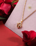 The Divine Om 925 Silver Pendant by Chandrani Pearls India is displayed on a white surface, accented with red roses for a feminine touch. Its elegant Om-shaped design makes it a unique and graceful accessory.
