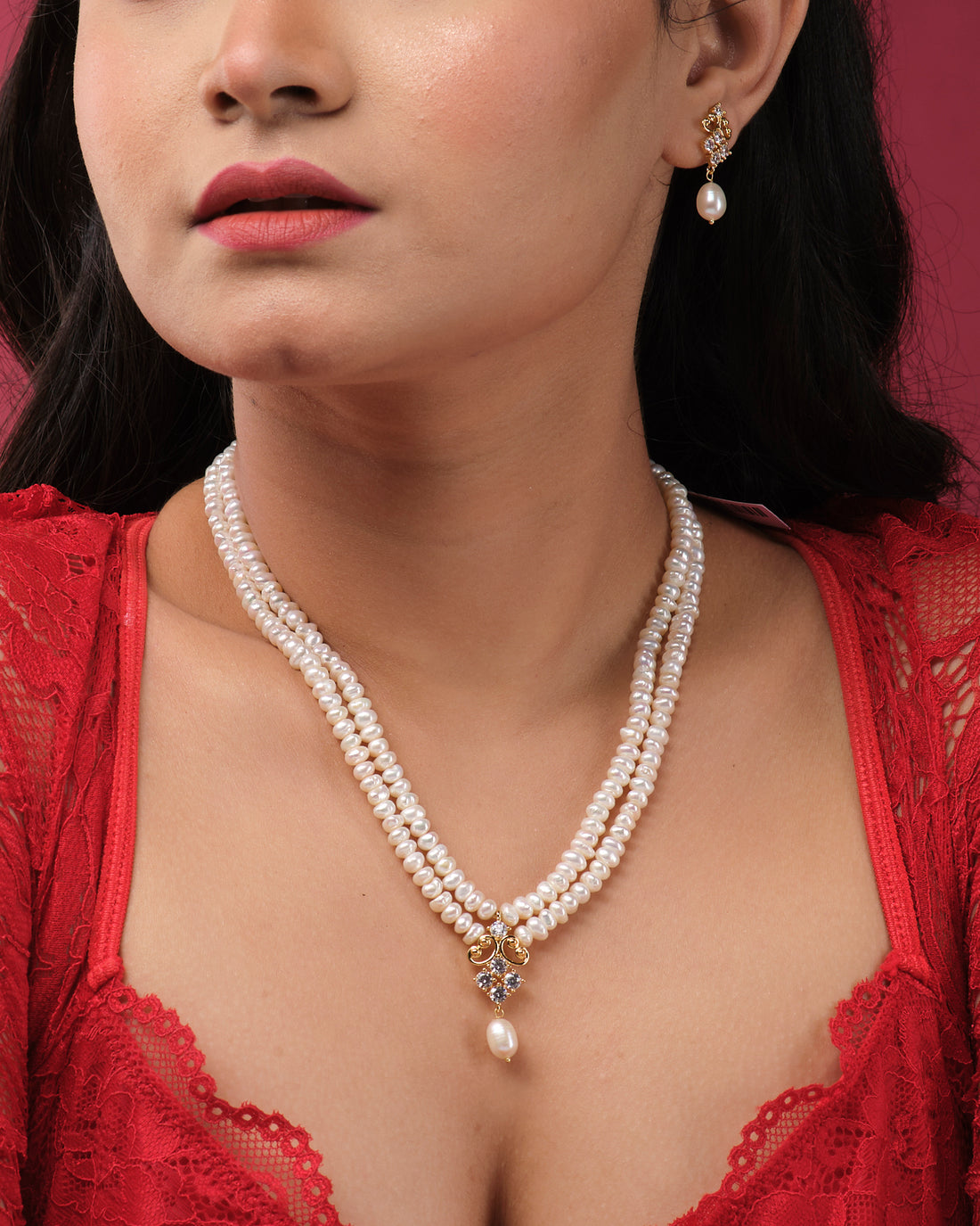 The Vintage Pearl Necklace Set by Chandrani Pearls India features a central pendant and matching pearl drop earrings, radiating natural beauty and elegantly displayed on a white jewelry stand.