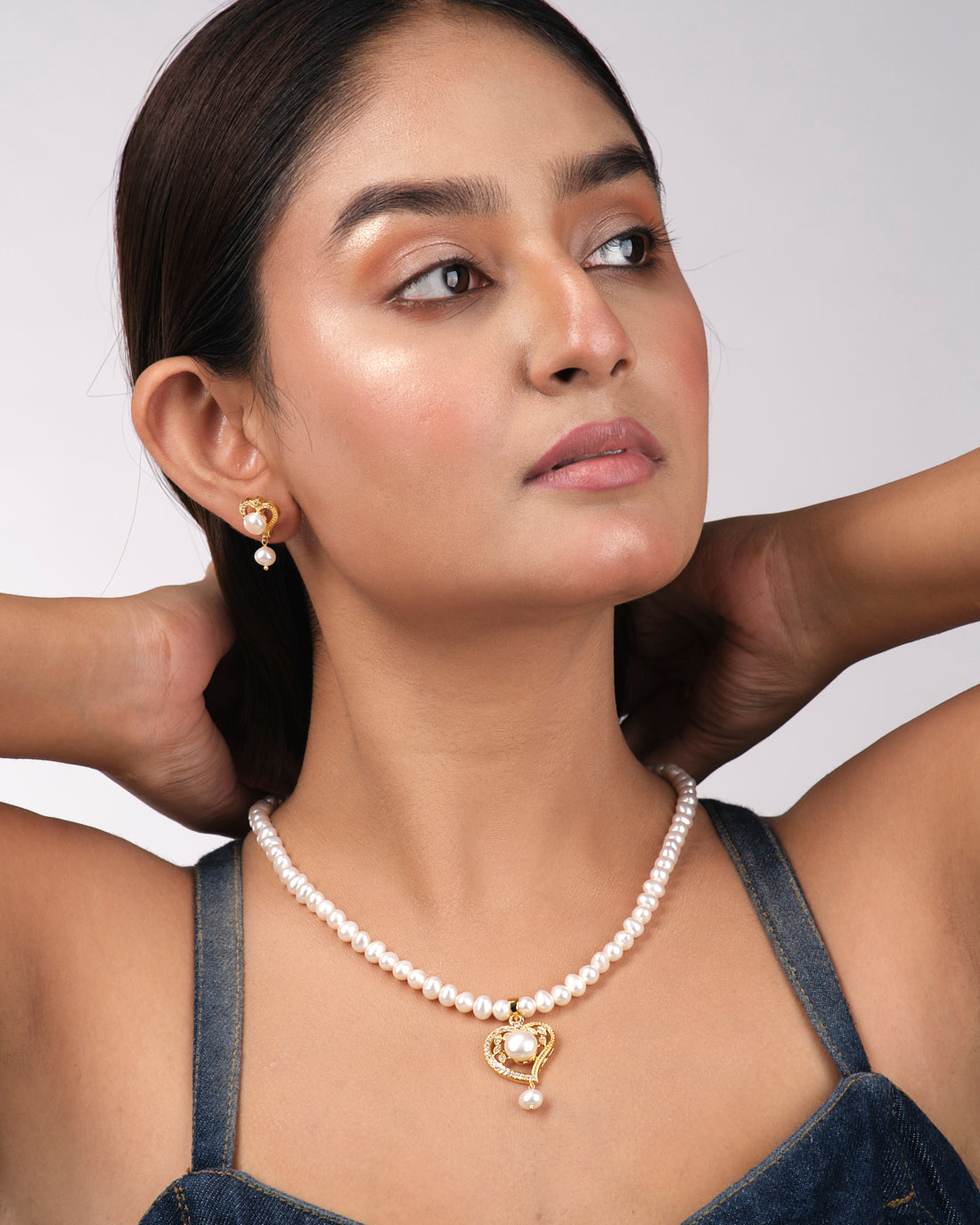 Chandrani Pearls India Heart Pearl Necklace Sets: gold heart-shaped pearls with sparkling stones and matching earrings, elegantly displayed on a light yellow background—ideal for the modern woman.