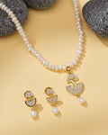 The Modern Necklace Pearl Set by Chandrani Pearls features a gold and CZ crystal pendant with matching earrings, beautifully displayed on yellow with black stones—ideal for the stylish woman.
