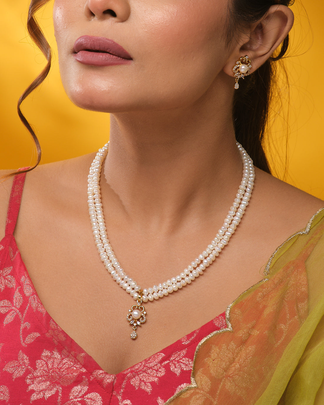 The Elegant round-cut CZ pendant with matching earrings by Chandrani Pearls, displayed on a navy stand, offers timeless style—designed to add everyday sparkle to your look.