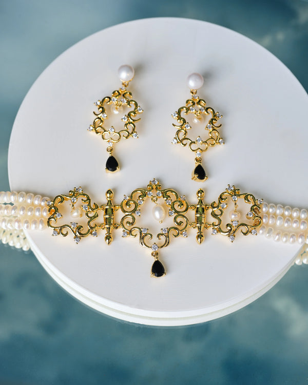The Chandrani Pearls Bridal Pearl & CZ Necklace Set features a beautifully crafted choker with glowing pearls and CZ accents, plus matching earrings—ideal for brides and elegantly displayed on a round white surface.