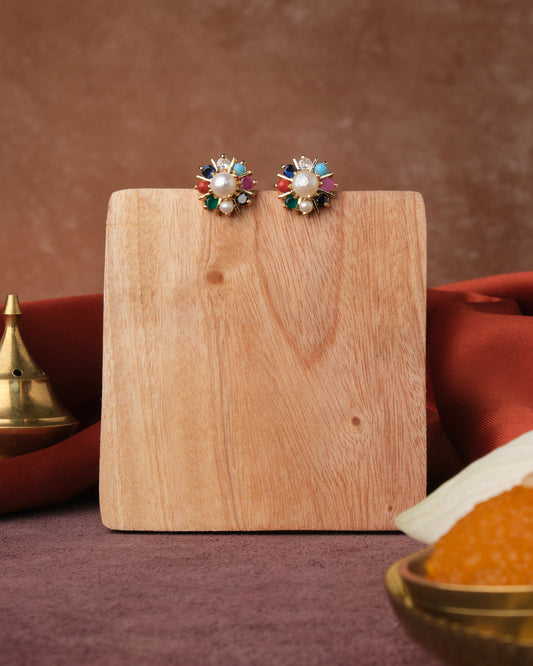 A wooden block with Chandrani Pearls India's Navratan CZ Stud Earring on it.