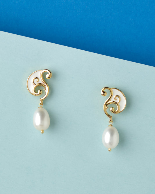 A pair of Chandrani Pearls Sophisticated Dainty Pearl Drop Earrings on a blue background.