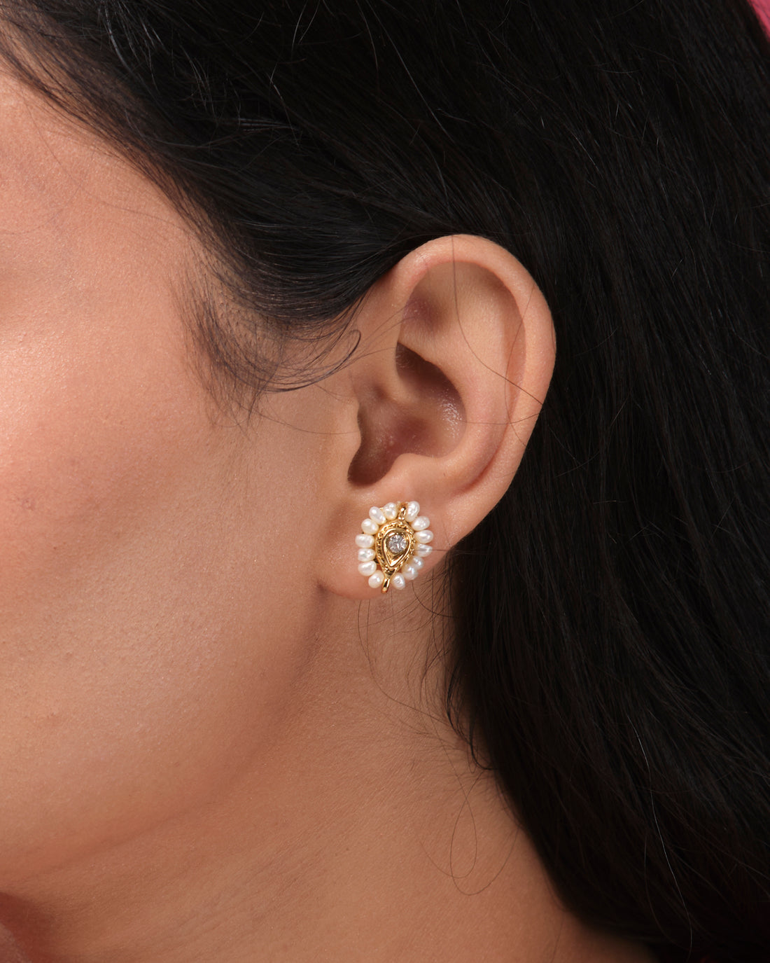Simple CZ Stud Earrings by Chandrani Pearls India, elegantly displayed on a white rectangular block against a softly blurred floral background.