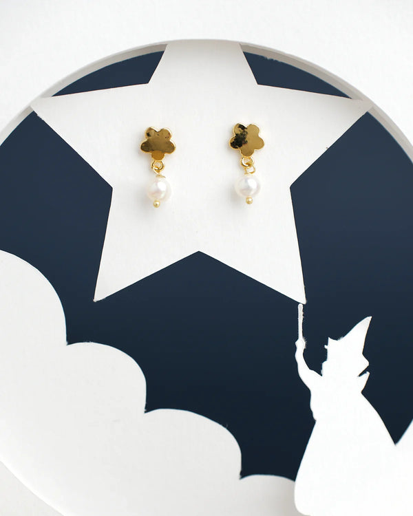 Gold and pearl earrings from Chandrani Pearls India showcased on a star cutout featuring a wizard silhouette.