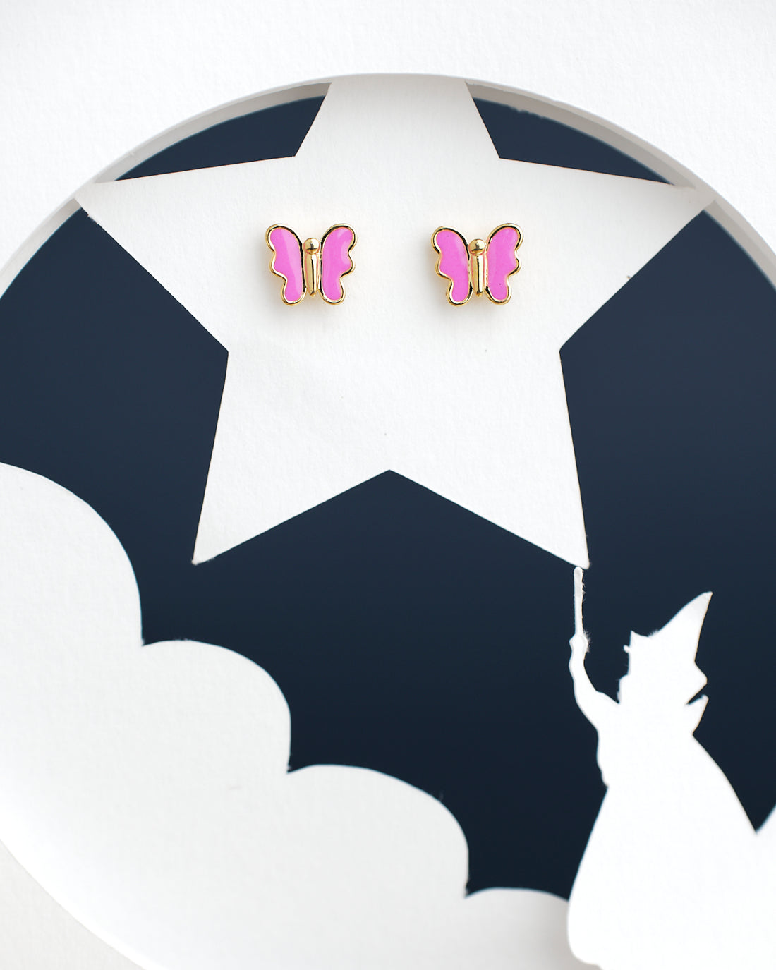 The Pretty Pink Butterfly earrings by Chandrani Pearls India are displayed on a star cutout, with a girl's silhouette holding an umbrella in the foreground.