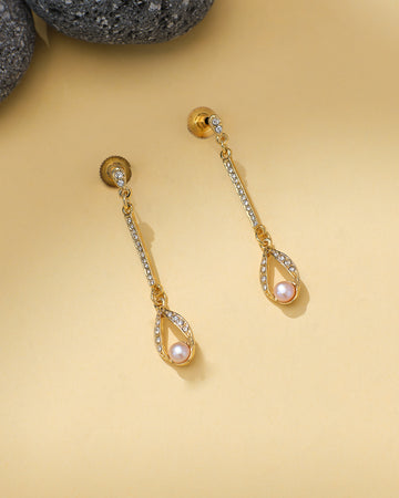 Chandrani Pearls' Pearl Hoops with CZ Embellishments feature a pink pearl teardrop set with sparkling stones, elegantly displayed on a beige background beside dark stones.