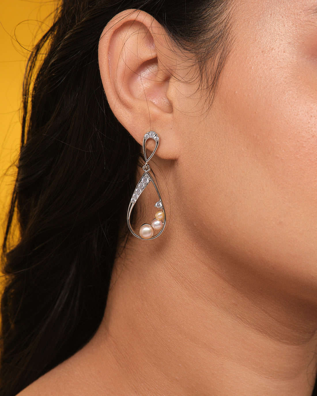 Chandrani Pearls' Sophisticated pearl drops, accented by dazzling CZ crystals, are showcased on a textured blue box with cream fabric—ideal for adding evening elegance to any outfit.