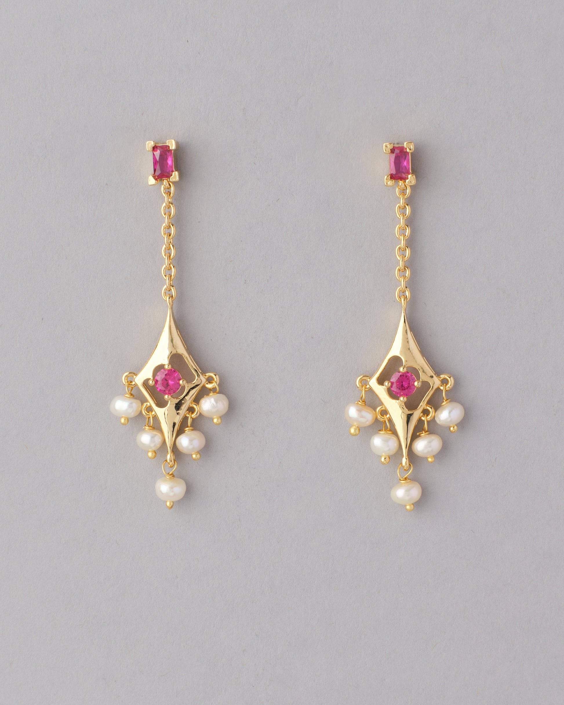 Ethnic Pearl Hanging Jhumkas with pink gemstones and pearl accents on a gray background by Chandrani Pearls India.